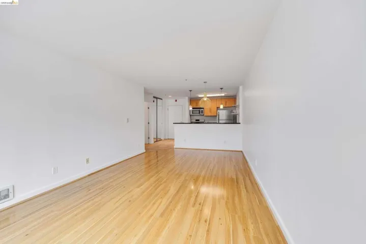 Bright living space featuring natural wood-finish flooring and white walls