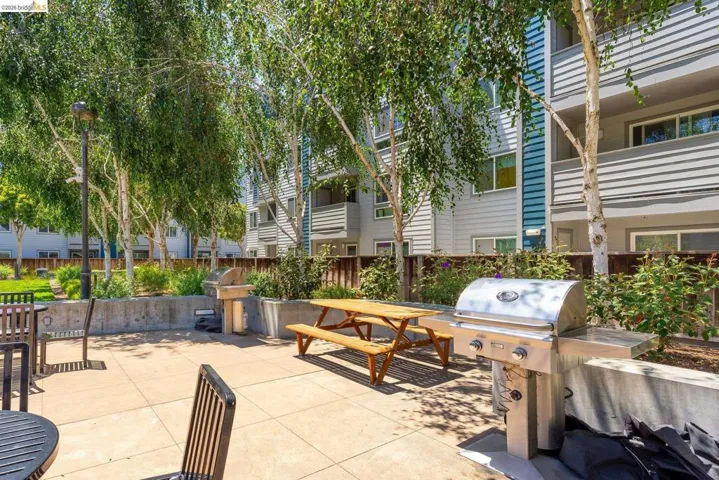 Outdoor grilling station featuring a stainless steel grill with side burners, concrete countertop, and a built-in basin