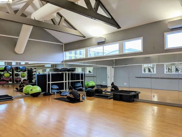 Fitness center featuring wood-finish flooring and extensive mirrored walls