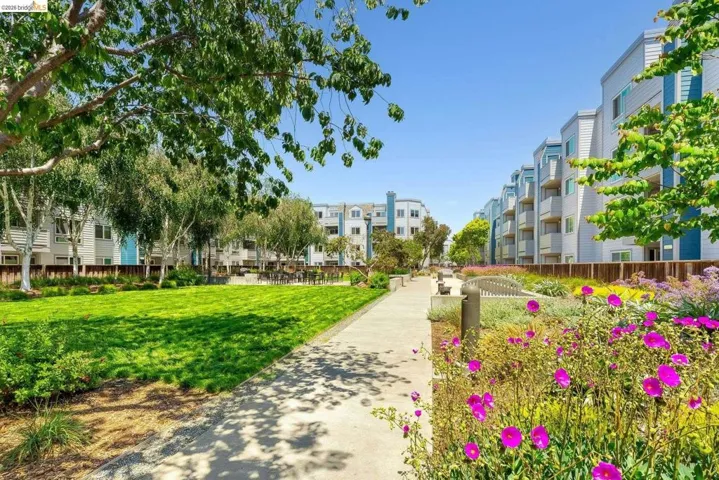 Community green space featuring a paved walkway and vibrant floral landscaping