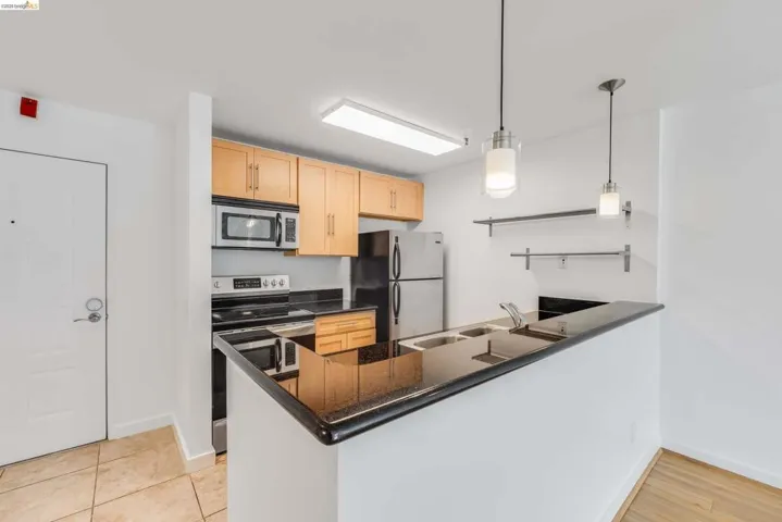 Kitchen featuring light wood cabinetry and dark countertops