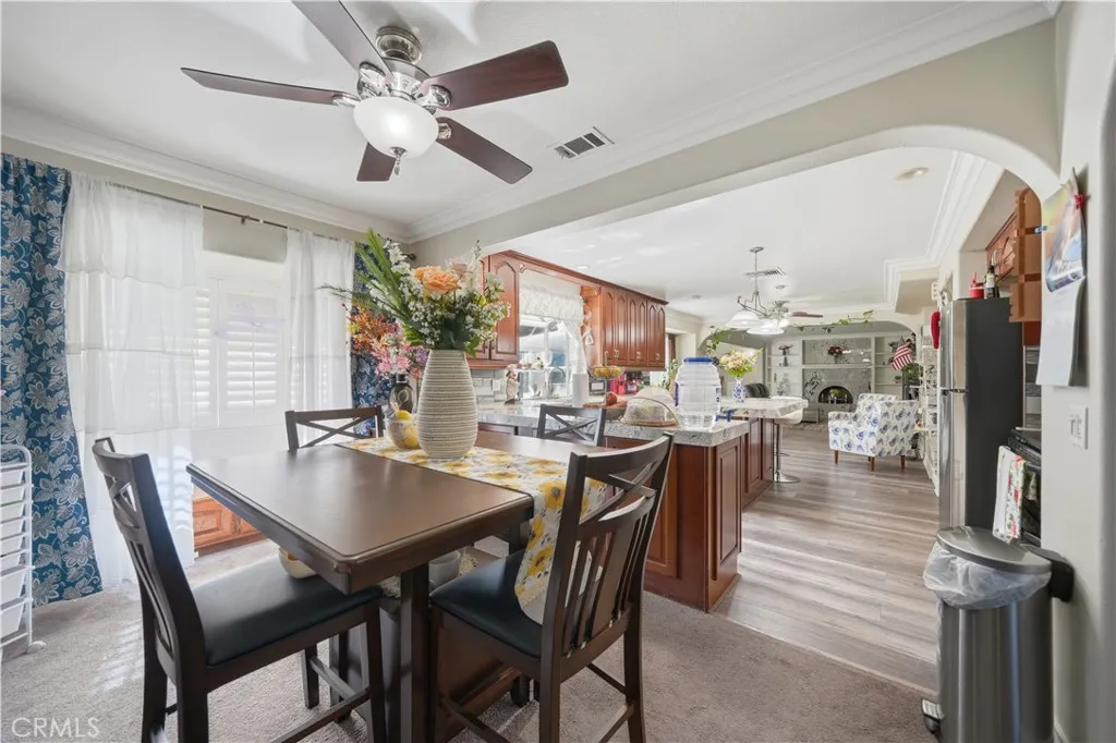 Breakfast area with ceiling fan opens to the kitchen through and arched opening.