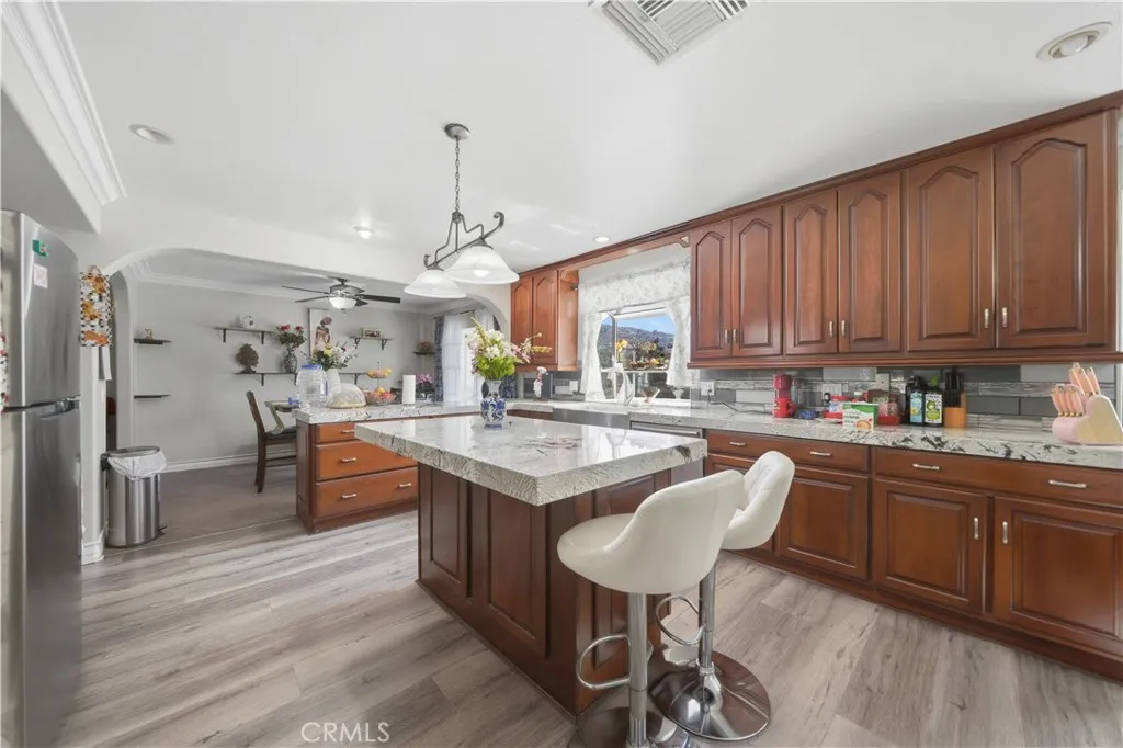 Kitchen features stainless steel appliances and a farm sink with window overlooking the pool and backyard.
