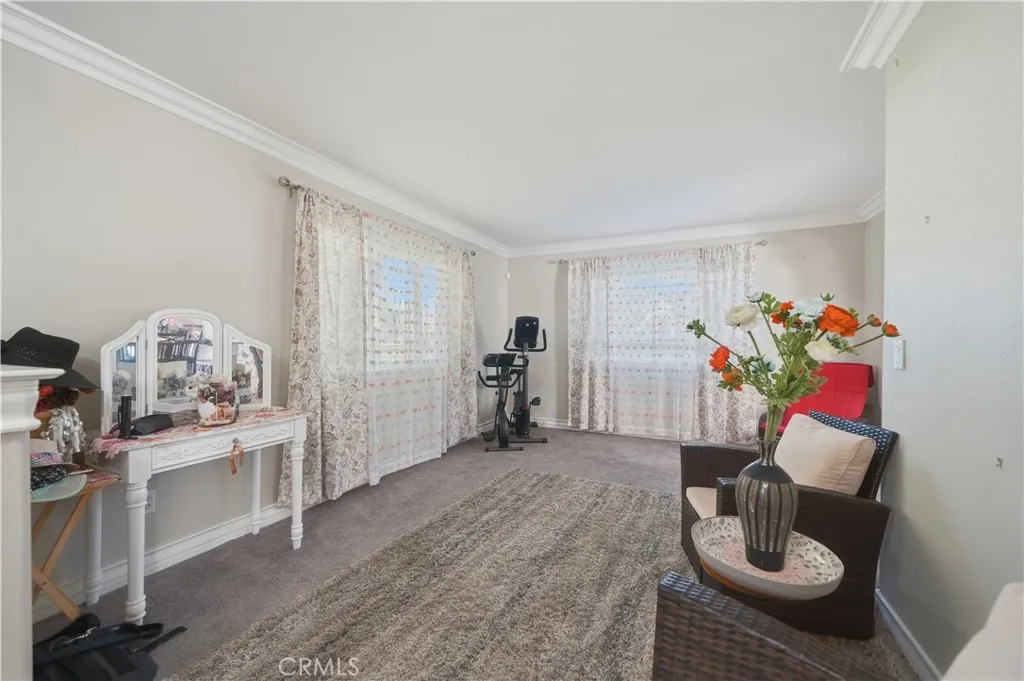 Formal Living room to the left of the entry featuring plush carpet, upgraded baseboards and crown molding.