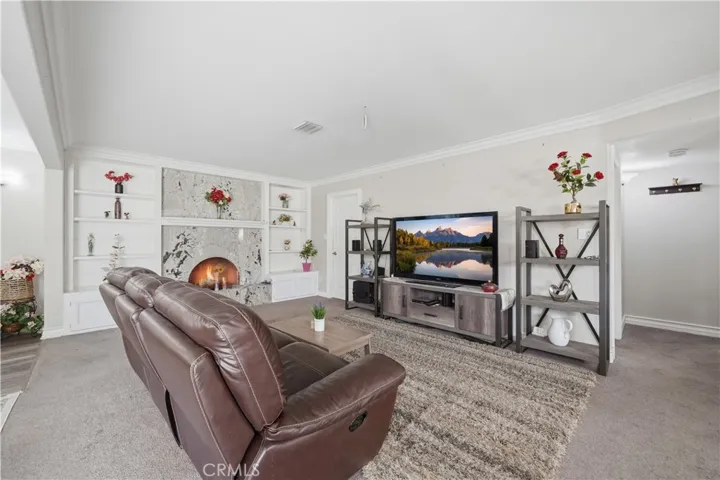 Family Room with arched fireplace encompassed with slab granite surround, matching the kitchen counters and stairs