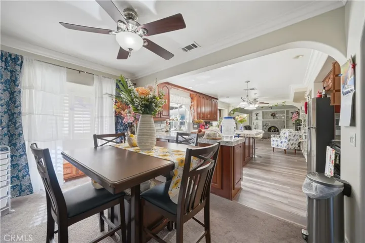 Breakfast area with ceiling fan opens to the kitchen through and arched opening.