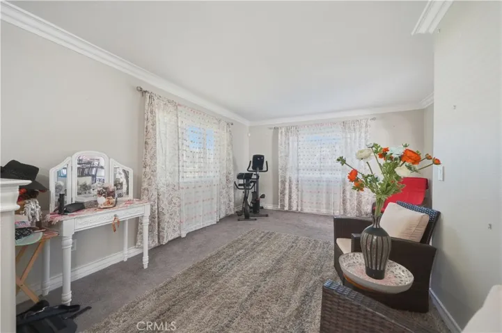 Formal Living room to the left of the entry featuring plush carpet, upgraded baseboards and crown molding.