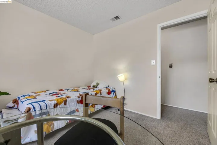 Neutral-toned walls complement the textured gray carpeting
