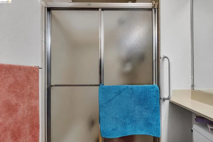 Shower enclosure featuring frosted glass sliding doors with a silver-tone frame