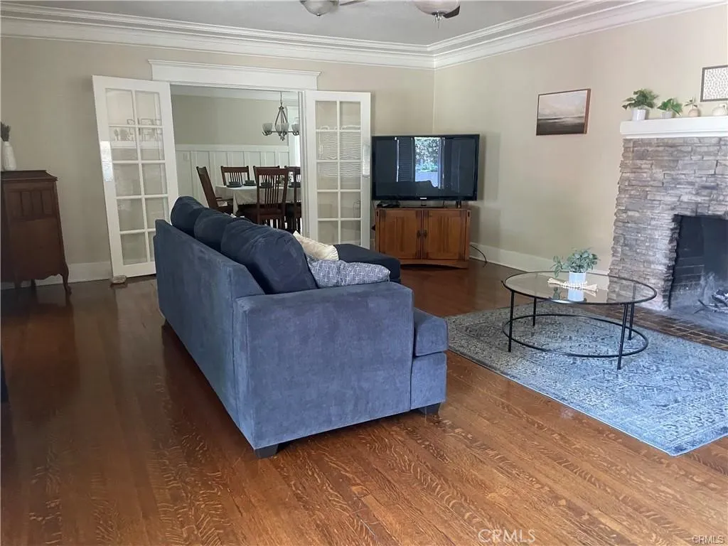 Spacious living room with crown molding and original, refinished hard wood floors.