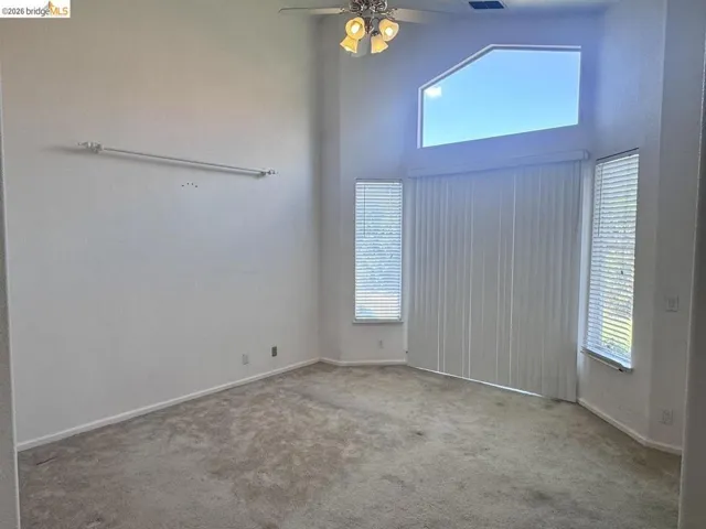 Room featuring vaulted ceilings and a ceiling fan