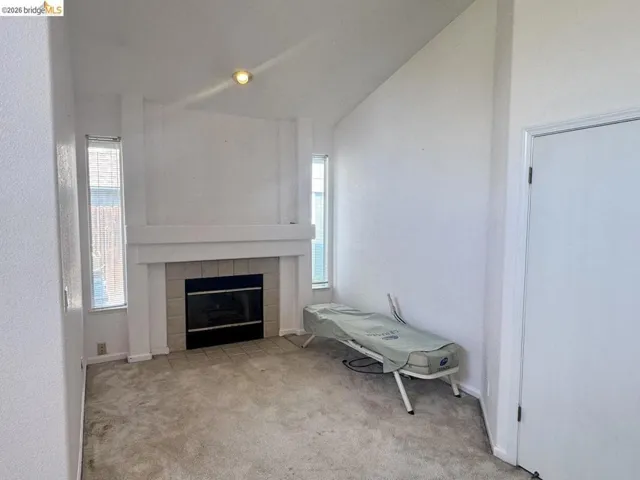 Living space featuring a central fireplace with a tiled surround and mantle