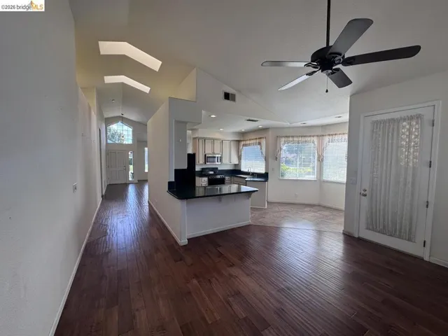 Vaulted ceilings with skylights and rich wood-finish flooring define this open concept space