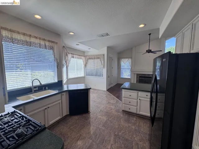 Kitchen with L-shaped counter, dual basin sink, and gas range