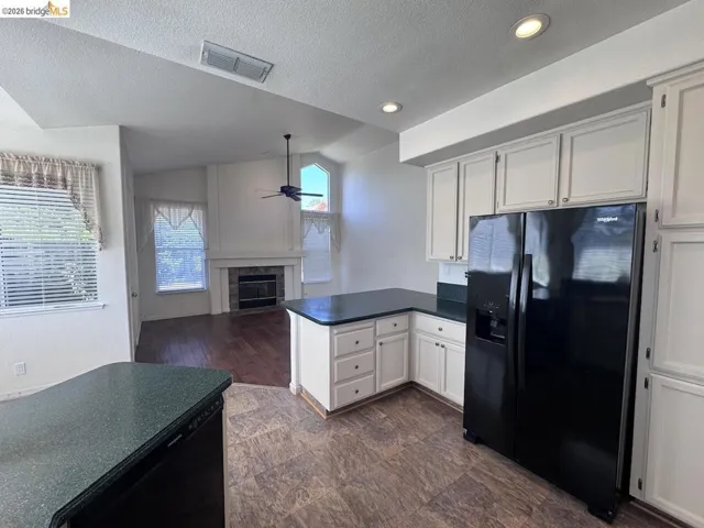 Kitchen featuring white cabinetry, dark speckled countertops, and recessed lighting