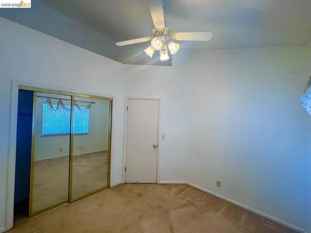 Room featuring vaulted ceilings and a ceiling fan with integrated lighting