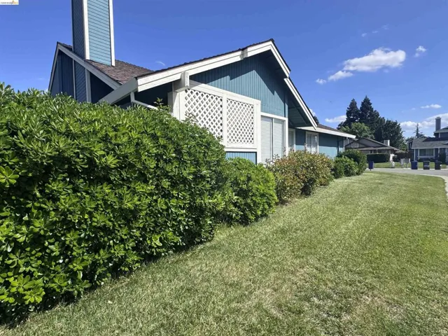 Exterior residence featuring blue siding, white trim, and a prominent chimney