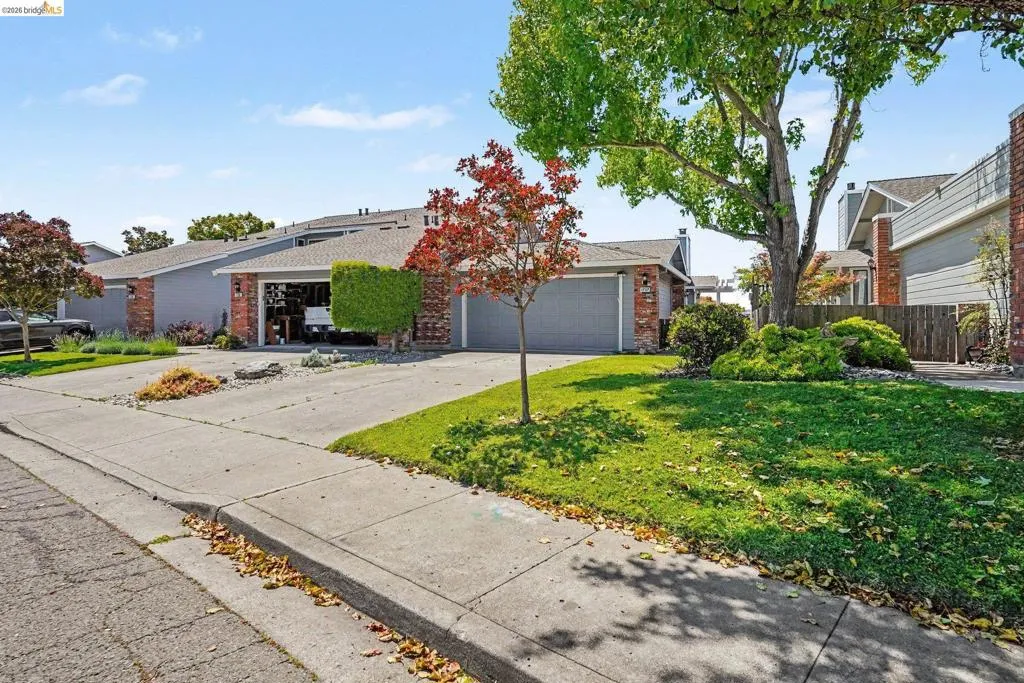 Single-story residence featuring a brick facade, dual garage doors, and a concrete driveway