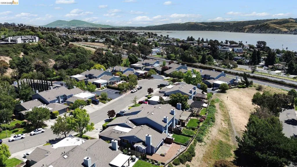 Aerial perspective showcasing a residential community with varied rooflines and surrounding green spaces