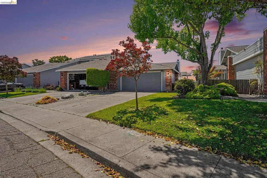 Single-story residence featuring a gray exterior with brick accents and an attached two-car garage