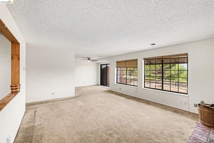 Expansive interior space featuring light-toned carpeting and white walls