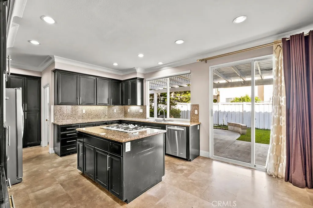 Kitchen windows and sliding glass door is open to the backyard area.