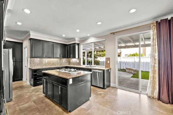 Kitchen windows and sliding glass door is open to the backyard area.