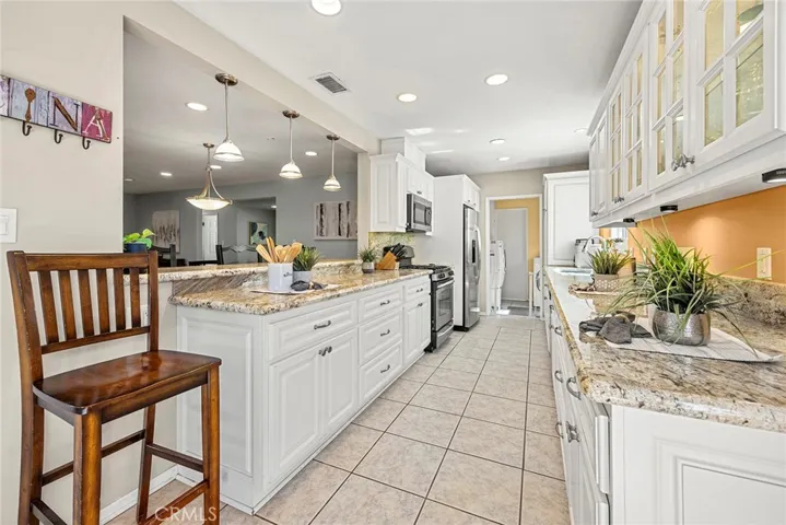 Upgraded galley-style Kitchen with granite countertops and opening to Dining Room.