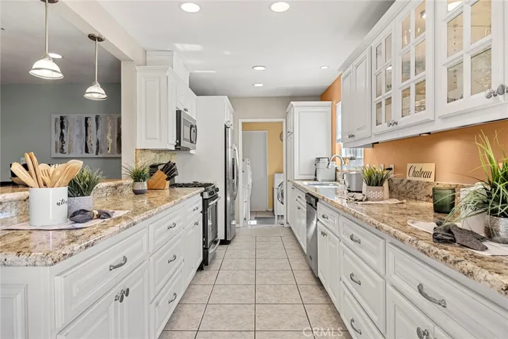 Light and Bright Kitchen with white cabinetry leading to the separate laundry room and bathroom.