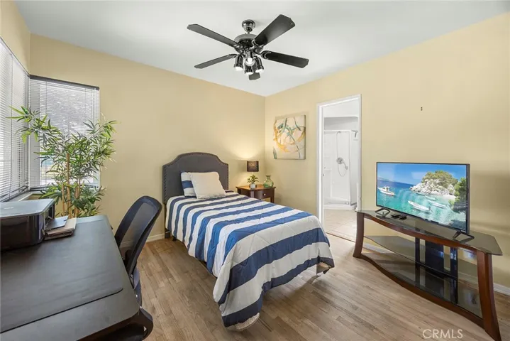 Bedroom #1 - main level secondary bedroom w/ ceiling fan and w/ en suite bathroom (shower, toilet & sink).