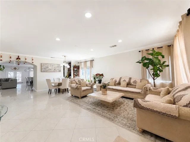 Entry with view of elegant living/dining room and arched doorway to the open plan family room / kitchen / eating nook.
