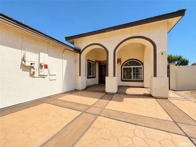 Shaded front entranceway with one of the garages to the left of the photo