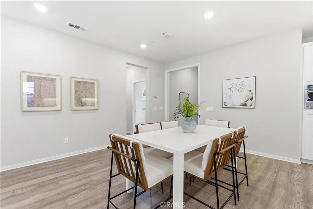 Dedicated dining area with open-concept layout, luxury vinyl plank flooring, recessed lighting, and seamless flow to the kitchen and living spaces.
