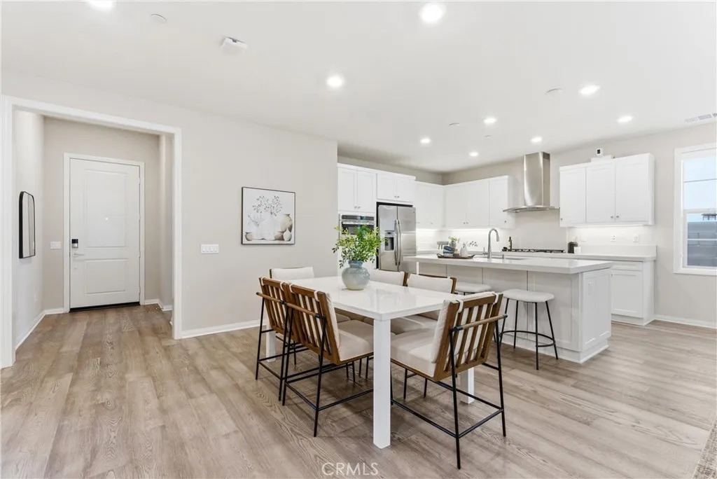 Open dining area adjacent to the kitchen with oversized island, quartz countertops, recessed lighting, and functional open floor plan ideal for entertaining.