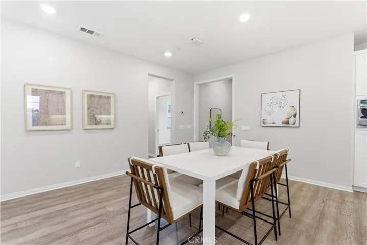 Dedicated dining area with open-concept layout, luxury vinyl plank flooring, recessed lighting, and seamless flow to the kitchen and living spaces.
