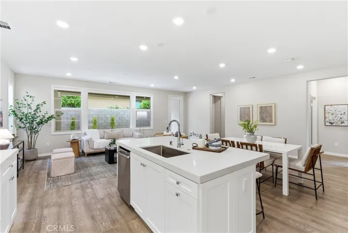 Open-concept kitchen and living area featuring oversized island, recessed lighting, large windows, and seamless indoor-outdoor connectivity.