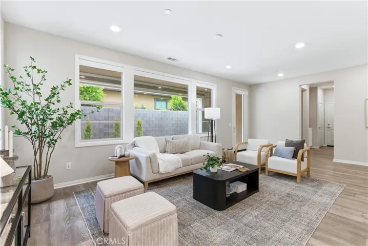 Open-concept living area with spacious seating arrangement, modern finishes, recessed lighting, and direct connection to the kitchen and dining spaces ideal for entertaining.