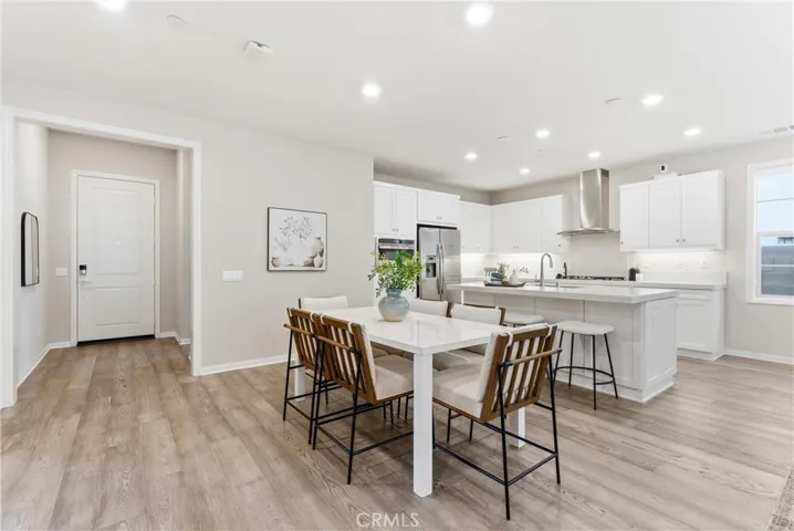Open dining area adjacent to the kitchen with oversized island, quartz countertops, recessed lighting, and functional open floor plan ideal for entertaining.