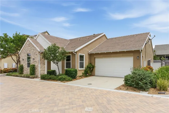Front exterior view showcasing the private driveway, contemporary architecture, tiled roof, and inviting curb appeal within a well-maintained neighborhood setting.