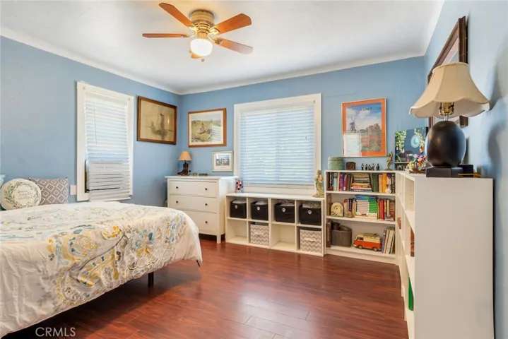 The large primary bedroom also has framed windows, upgraded flooring, and a ceiling fan with light.