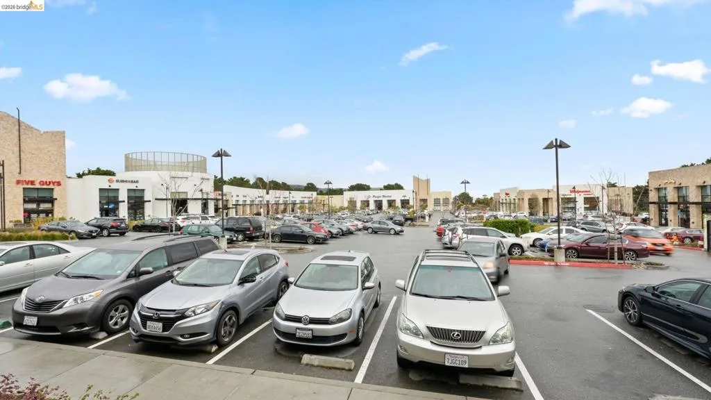 Expansive retail parking area with multiple commercial establishments visible