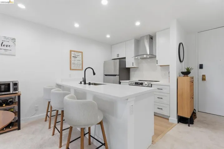 Modern kitchen featuring an island with a built-in sink and seating