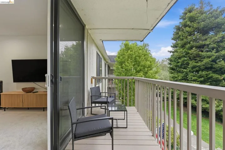 Outdoor balcony featuring composite decking and a light-colored railing