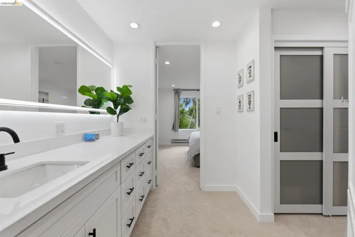Extended vanity with white countertop, undermount sink, and matte black faucet