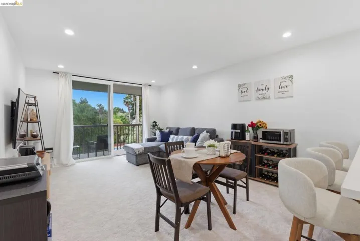 Open-concept living space with light-colored carpeting throughout
