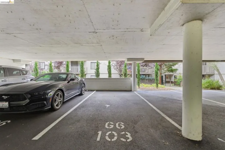 Covered parking space with concrete ceiling and marked ground
