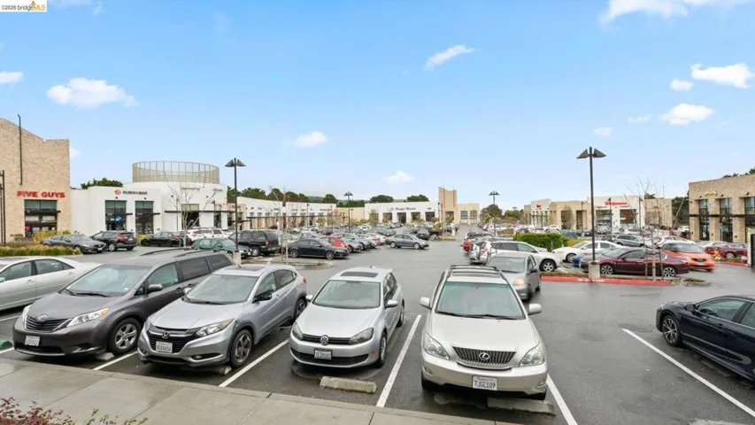 Expansive retail parking area with multiple commercial establishments visible