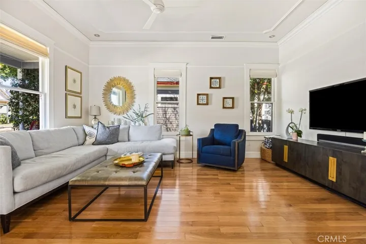 Living room with great natural light, timeless hardwood floors, and detailed moulding.