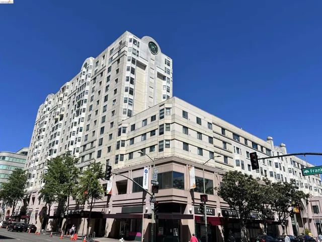 Multi-story residential and commercial building featuring varied window designs and a prominent rooftop clock