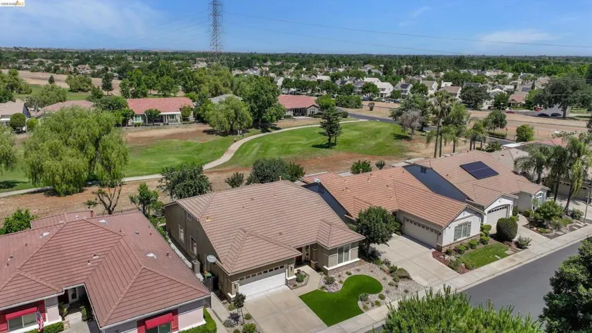 Aerial overview of a residential neighborhood featuring single-story homes with tile roofs and landscaped front yards